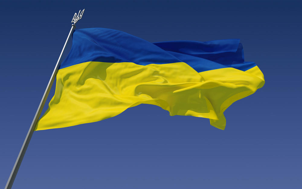 blue and yellow ukrainian flag on flag pole waving in the wind 